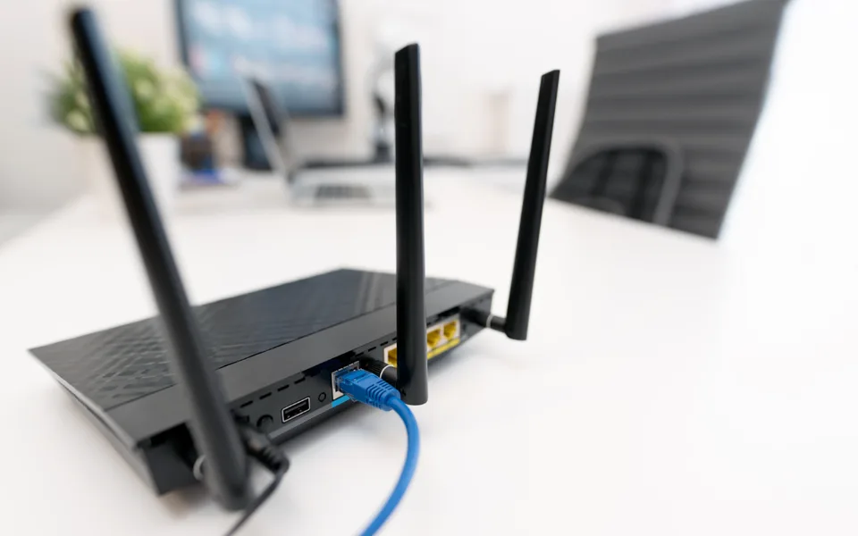 Wifi-router met aangesloten netwerkkabel op een bureau